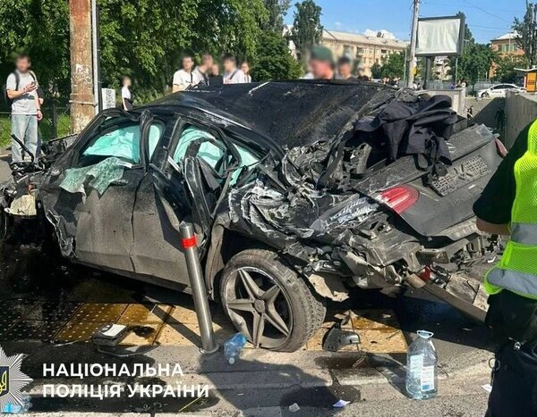 Правоохоронці конвоюють водія, який спричинив аварію зі смертельними наслідками.