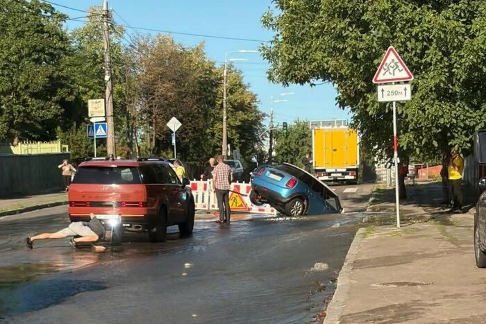 У Подільському районі Києва авто провалилося у яму через аварію на водогоні (фото)