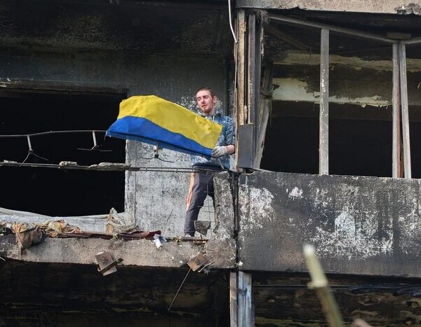 Киянин прикрасив балконом зруйнованого будинку прапором незламності