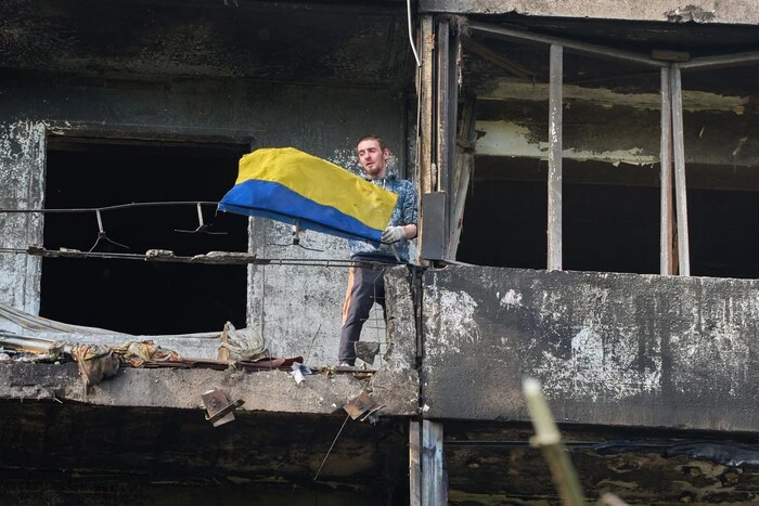 Символ незламності: житель Києва вивісив прапор на балконі понівеченого балістикою будинку